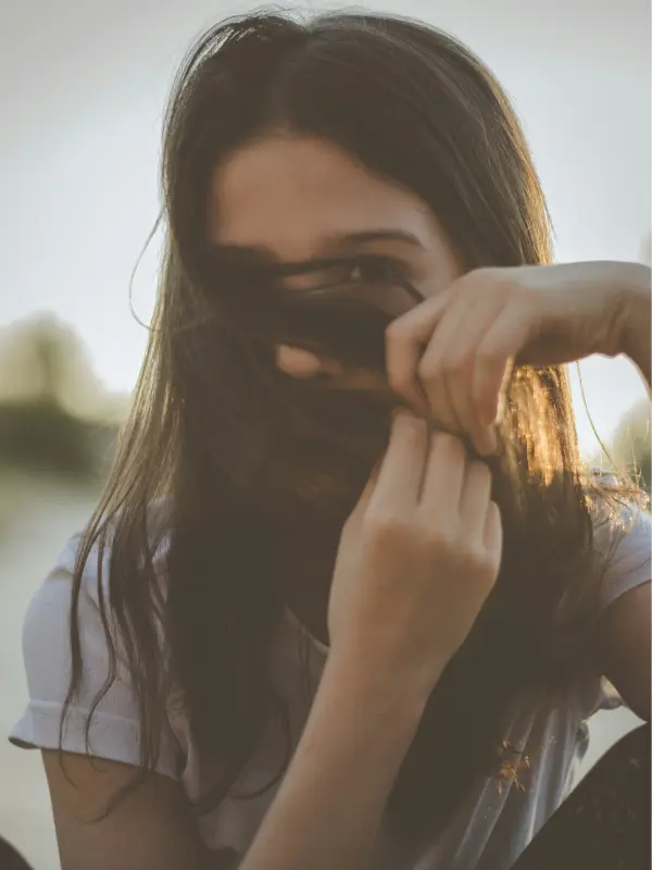Femme se cachant le visage, illustrant les stratégies d'évitement liées à la peur de rougir