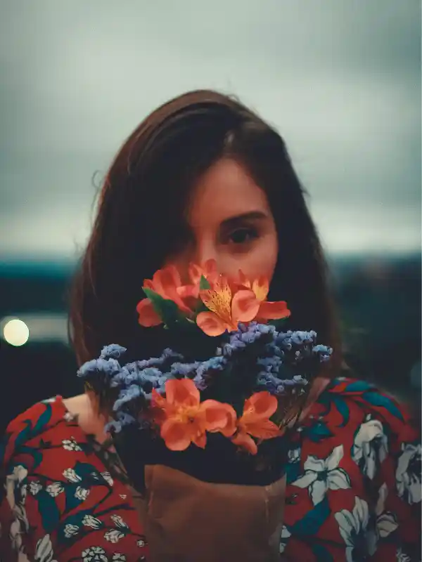 Femme sereine entourée de fleurs illustrant le mieux-être après un accompagnement pour les crises d'angoisse