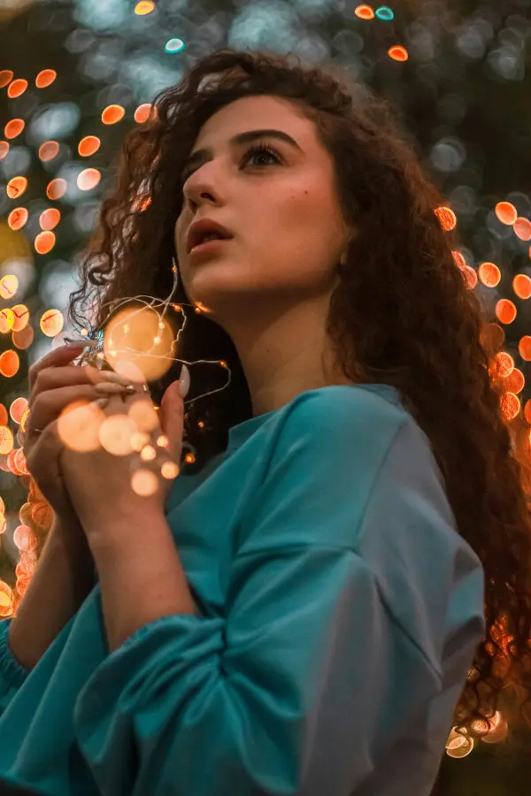 Femme sereine tenant des lumières, symbolisant la reprise de contrôle sur l'anxiété grâce à l'hypnose