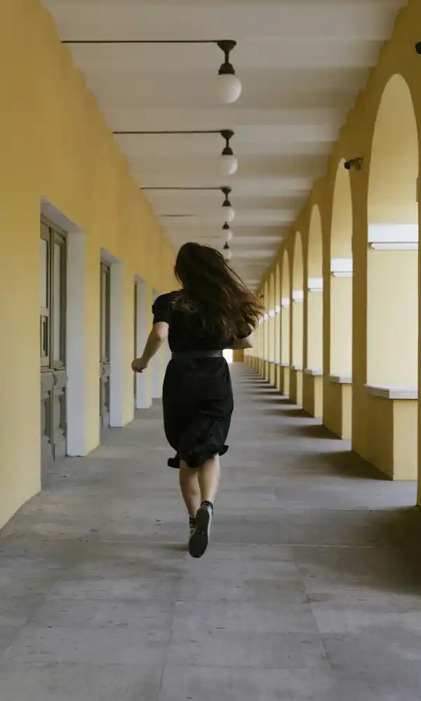 Femme courant dans un couloir illustrant l'évitement et la fuite lors d'une crise d'angoisse