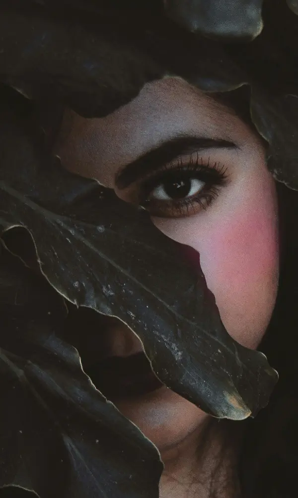 Femme se cachant le visage dans des fleurs : pourquoi je rougis facilement, illustration de l'éreutophobie